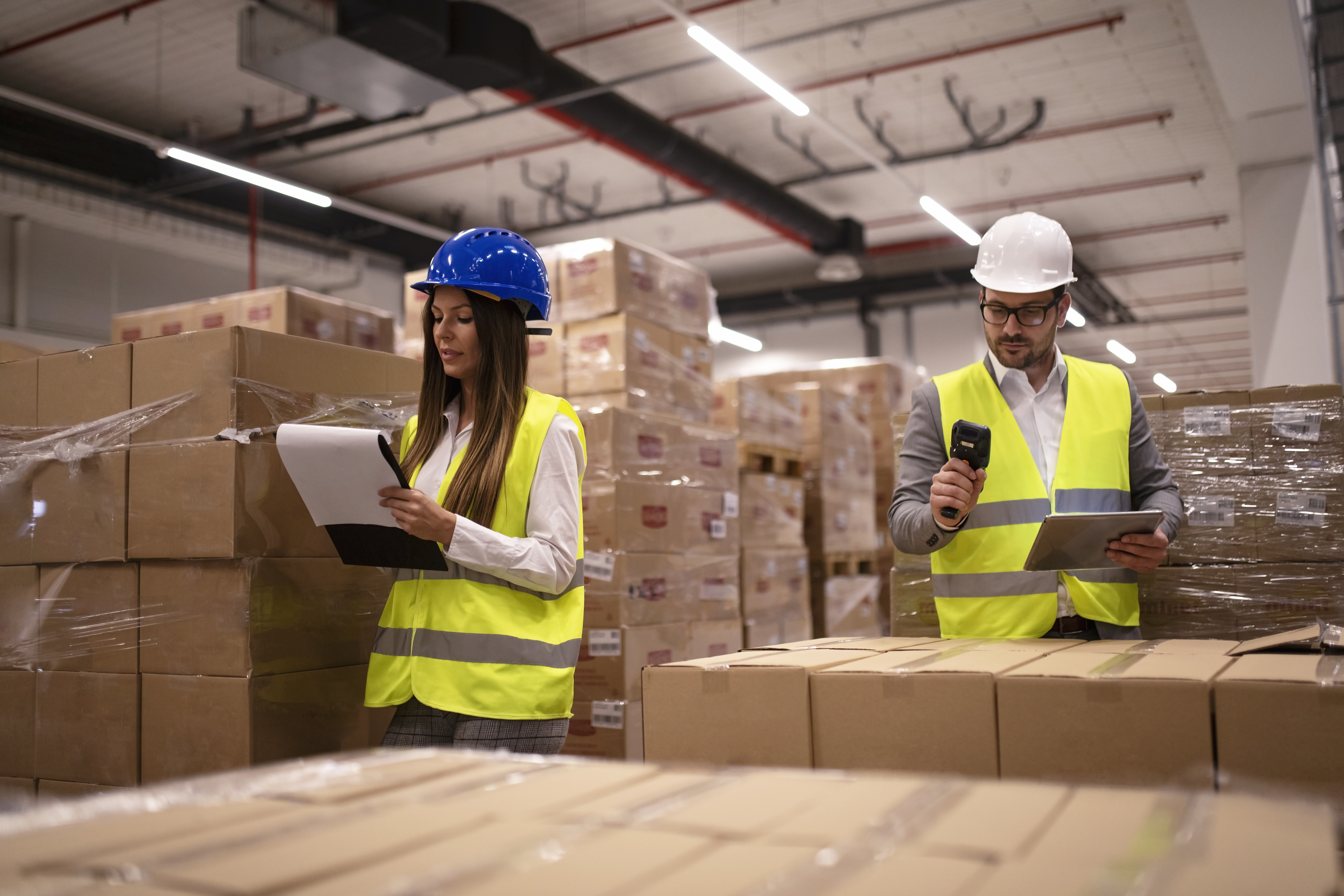 warehouse workers using bar code scanner and tablet and checking goods inventory.